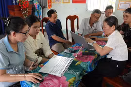 玉贝乡芳贵2村社区数字技术小组成员指导群众在线提交行政手续材料。图：越通社