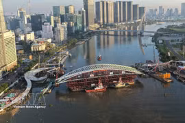 装载主跨结构的驳船就位于西贡河步行桥项目合龙位置全景图。图：越通社