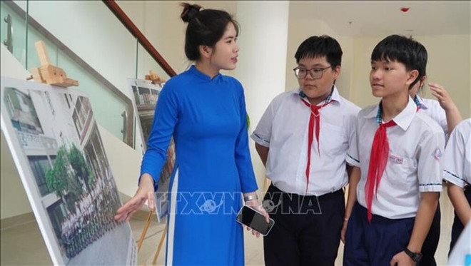 向学生们介绍减塑旅游产品。图自越通社 170620-vna-potal-hue-le-ra-mat-trung-tam-dao-tao-thuc-hanh-nghe-du-lich-ben-vung-stand.jpg