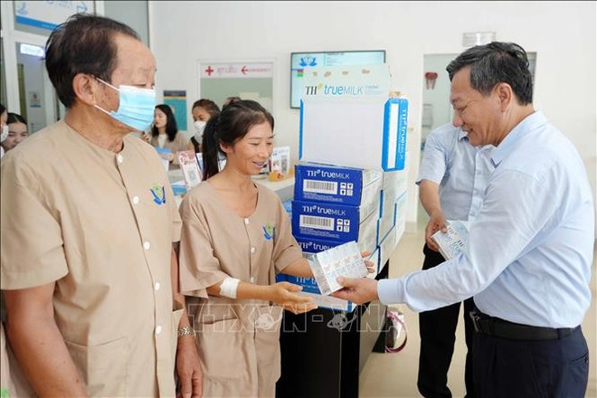 阮明心大使向正在河内-万象医院接受治疗的患者赠送问问品。图自越通社 viet-lao-1306025-03.jpg