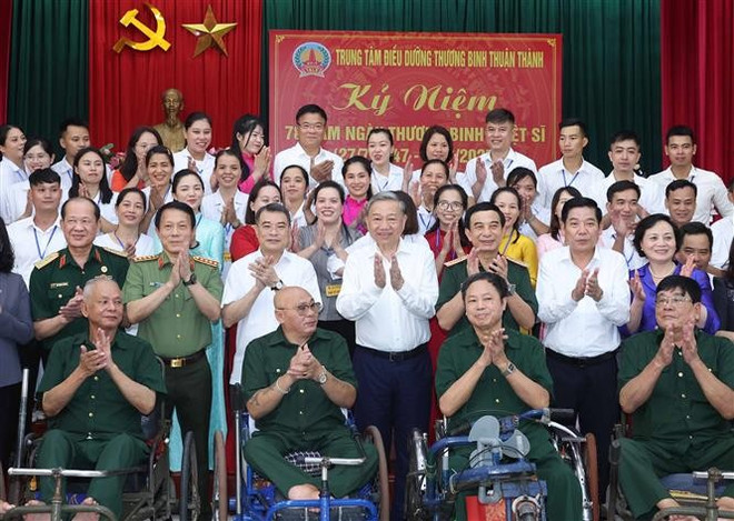 越共中央总书记苏林和优抚对象合影。图自越通社 vna-potal-tong-bi-thu-to-lam-tham-trung-tam-dieu-duong-thuong-binh-thuan-thanh-8150367.jpg