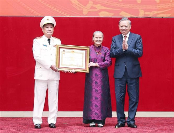 苏林总书记代表党和国家领导人向已故公安部部长黎明香的亲属代表授予“人民武装力量英雄”称号。图自越通社 vna-potal-tong-bi-thu-gap-mat-can-bo-cong-an-cap-cao-nghi-huu-8214716.jpg