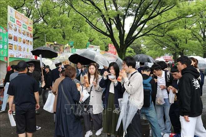 尽管下着大雨,本次文化节仍然吸引大量游客前来品尝越南美食。图自越通社 uuid01d6c753-bbcd-452b-9dab-3317c812a964code001library1type1mode1loctruecaptrue.jpg