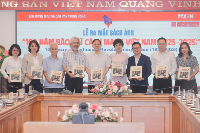 越通社党委书记、社长武越庄向代表们赠送《越南革命新闻100年(1925-2025)》画册。图自越通社 vna-potal-le-ra-mat-sach-anh-100-nam-bao-chi-cach-mang-viet-nam-1025-2025-8083124.jpg