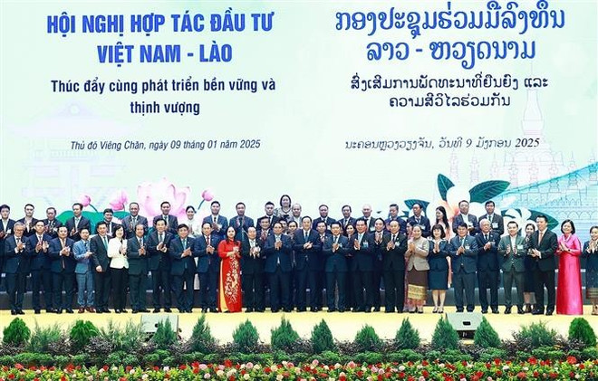 越南政府总理范明政与老挝总理宋赛·西潘敦和两国企业代表合影。图自越通社 vna-potal-thu-tuong-pham-minh-chinh-va-thu-tuong-sonexay-siphandone-dong-chu-tri-hoi-nghi-hop-tac-dau-tu-viet-nam-lao-2025-7798891.jpg