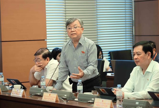 国会代表就学前儿童和学生学费减免政策展开讨论。图自越通社