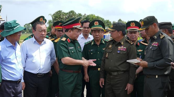越南国防部副部长黄春战中将（左三）与柬埔寨皇家陆军副总司令伊萨拉将军（右二）讨论在柬埔寨柴桢省柴桢县建设桑索瓦纳小学友谊项目计划。图自越通社