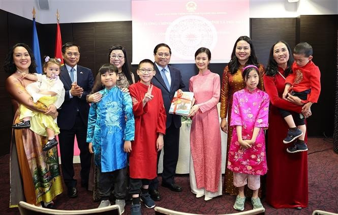 越南政府总理范明政和夫人向旅居爱沙尼亚的越南人赠送越南语书籍。图自越通社