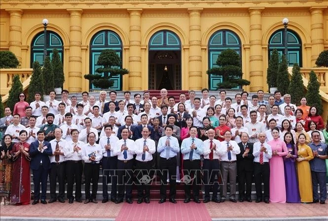 越南国家主席梁强在主席与艺人代表合影。图自越通社