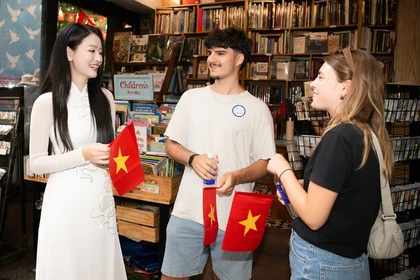 向国际游客赠送越南国旗。图自越通社