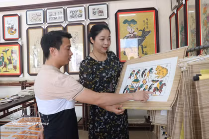 游客参观东湖民间画。图自越通社