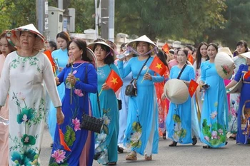 同塔省5500名妇女身穿传统奥黛参加“闪耀莲花”游行。图自越通社