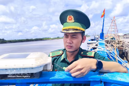 干豪边防检查站站长潘明王少校对渔船VMS设备进行检查。图自越通社