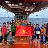 胡志明市海上执法力量向正在海上作业的渔民赠送国旗，并进行打击IUU相关内容宣传。图自越通社