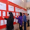 人们在河内第十三号选举单位查看候选人名单。图自越通社