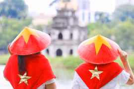 年轻人身穿金星红旗斗笠与配件，以此彰显爱国情怀。图自越通社