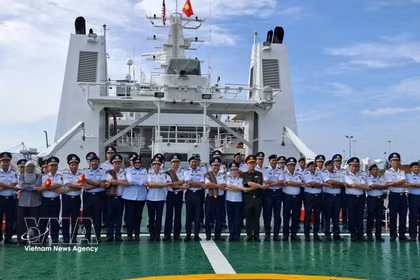 越南海警代表与马来西亚海事执法局（MMEA）彭亨州代表在CSB 8005号舰上，按东盟传统进行合影留念。图自越通社