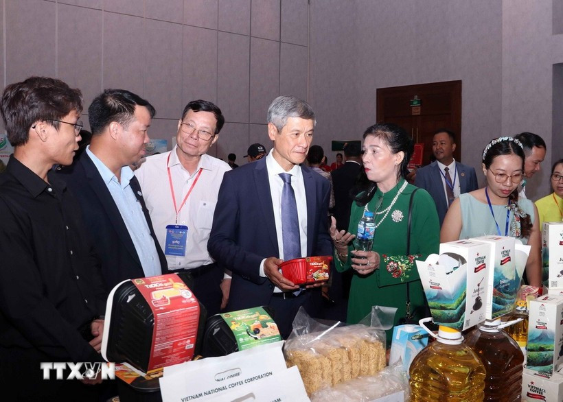 越南驻柬大使阮明宇和柬埔寨企业代表参观越南展位。图自越通社