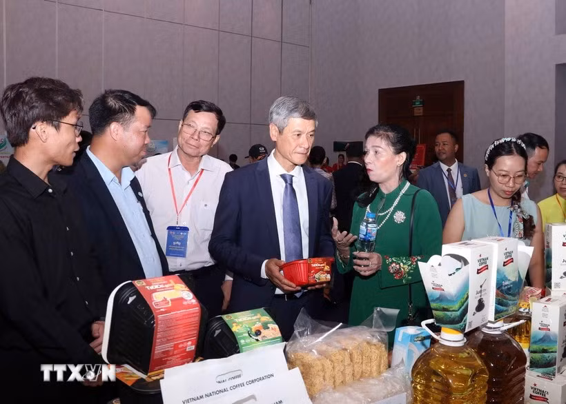 越南驻柬大使阮明宇和柬埔寨企业代表参观越南展位。图自越通社