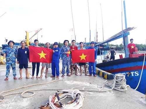 生存岛后勤技术服务中心干部人员向渔民赠送国旗。图自《人民军队》