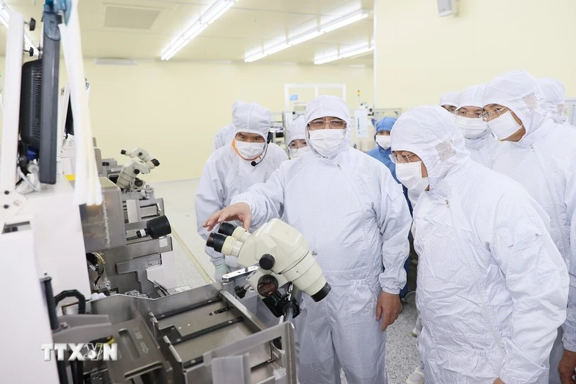 政府总理范明政参观Hana Micro Vina公司的半导体芯片生产线。图自越通社