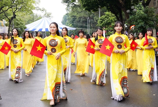 越南女性身穿奥黛跳民间舞蹈活动。图自越共电子报