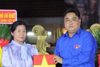 胡志明市团市委书记、胡志明市越南青年联合会主席吴明海向烈士家属移交烈士遗像。图自 muctim.tuoitre.vn