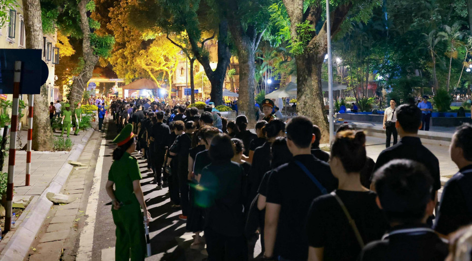 大家有序排队，排队队伍甚至达到了几公里之长，等待进入殡仪馆向阮富仲总书记致哀。图自越通社