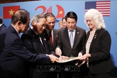 国家主席梁强与越美两国老兵及老兵家属一同观看战争遗物与资料。图自越通社