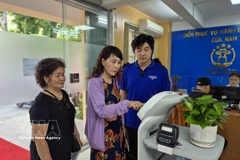 民众体验采用人工智能技术的AI机器人，以辅助办理行政手续。图片来源：越通社