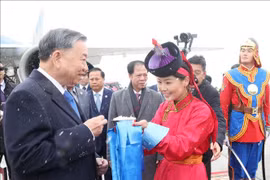 在成吉思汗机场，蒙古国姑娘按照传统习俗向越共中央总书记、国家主席苏林献上奶片。图自越通社