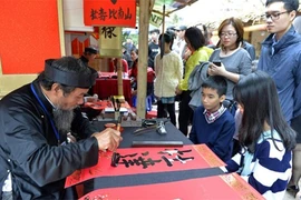 春初，青年赴文庙-国子监求字祈求平安、学习向上。（图片来源：越南《人民军队报》）