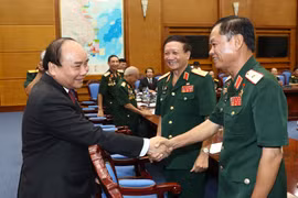 阮春福与长山部队老战士代表亲切握手。（图片来源：越通社）