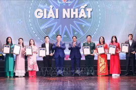 越南政府总理范明政和中央宣教部部长阮忠义向第九届全国对外新闻奖获得一等奖的作者颁发奖状。图自越通社