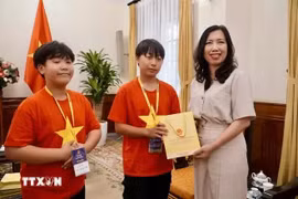 越南外交部副部长、海外越南人国家委员会主任黎氏秋姮向少儿们赠送礼物。图自越通社