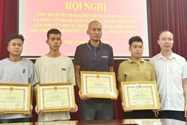 四名青年因勇敢救助火灾中受困人员而获得纸桥郡人民委员会的奖状。图自越通社