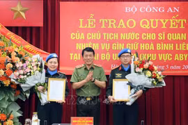 公安部副部长梁三光向2024 年赴联合国阿卜耶伊地区临时安全部队特派团执勤的两位公安部警官授予国家主席决定书。图自越通社