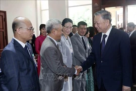 国家主席苏林与越南驻老大使馆干部人员和旅老越南人代表。图自越通社