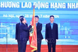 越南国会主席陈青敏将一等劳动勋章别在越南劳动总联合会传统旗帜上。图自越通社