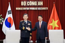 越共中央政治局委员、越南公安部部长梁三光上将（右）与韩国警察厅厅长赵智浩（Cho Ji Ho）。图自越通社
