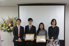 三菱日联金融集团代表Tooru Mera（左一）与越南驻日本大使馆公使林青芳（右一）向越南留学生发放学费津贴。图自越通社