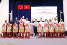 胡志明市越南祖国阵线委员会副主席范明俊向各位代表赠送礼物。图自越通社