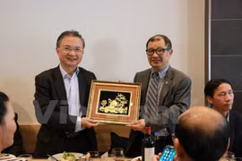 越南驻澳大利亚大使吴（左）向越南驻澳大利亚商人协会主席陈伯福赠送礼物。（图片来源：越通社）