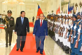 越南政府总理阮春福（右）与柬埔寨首相洪森(左）检阅仪仗队。（图片来源：越通社）