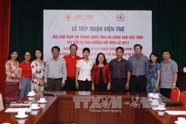 越南红十字会主席阮氏春秋（右五）与中国驻越南大使馆临时代办尹海虹（左六）同双方代表合影。（图片来源：越通社）