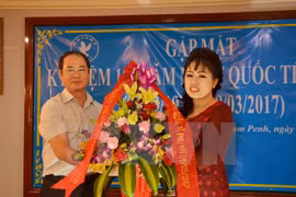 阮孟强参赞向越南驻柬埔寨妇女协会代表送鲜花（图片来源：越通社）