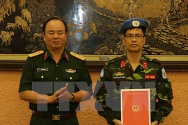 越南人民军副总参谋长范玉明上将（左）向阮国庆大尉颁发决定（右）。（图片来源：越通社）