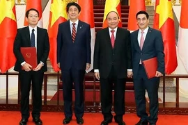 阮春福总理、日本首相安倍晋三、日本国际协力机构和越南财政部代表出席协议签署仪式。