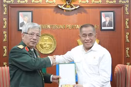 越南国防部副部长阮志咏（左）向印尼国防部长赠送纪念品。