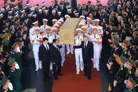  各位党和国家领导人将阮富仲总书记灵柩抬上灵车，送别总书记回到安息之地。。图自越通社